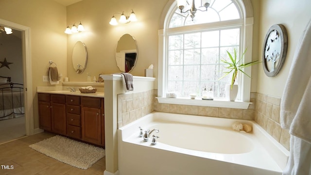 full bath with tile patterned floors, a garden tub, and vanity