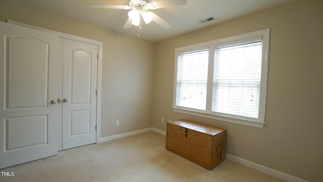 unfurnished bedroom with baseboards, visible vents, carpet floors, and ceiling fan