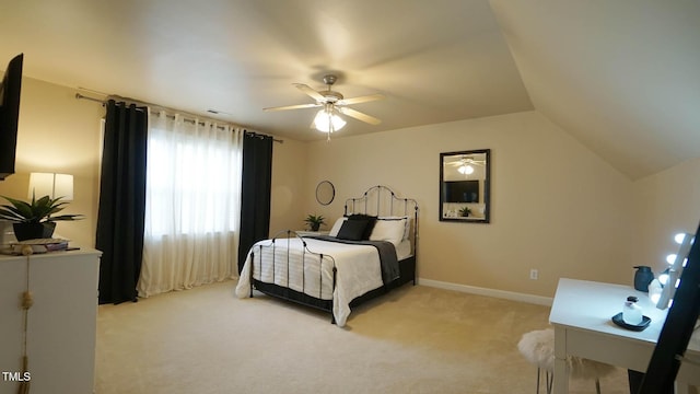bedroom with vaulted ceiling, light colored carpet, baseboards, and ceiling fan