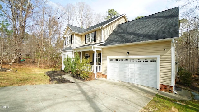 traditional-style house with covered porch, an attached garage, a shingled roof, and driveway