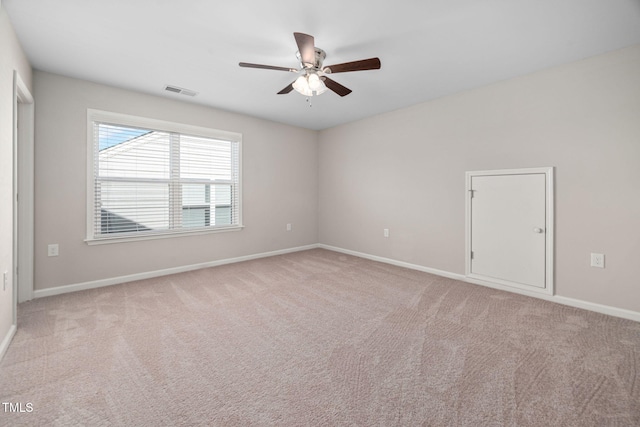 carpeted empty room featuring a ceiling fan, visible vents, and baseboards