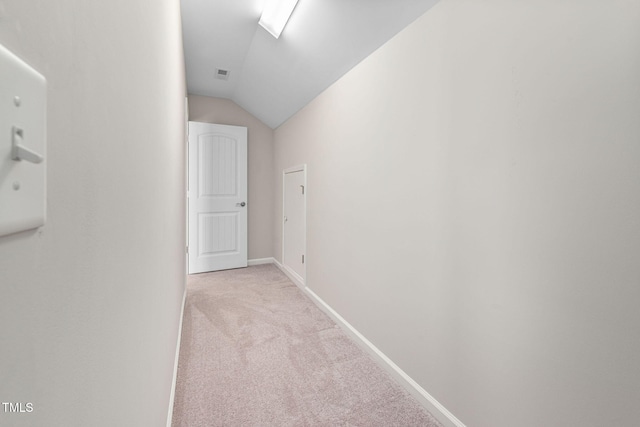 hall with light carpet, baseboards, visible vents, and lofted ceiling