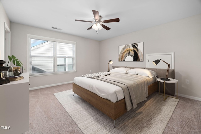 carpeted bedroom featuring a ceiling fan, visible vents, and baseboards