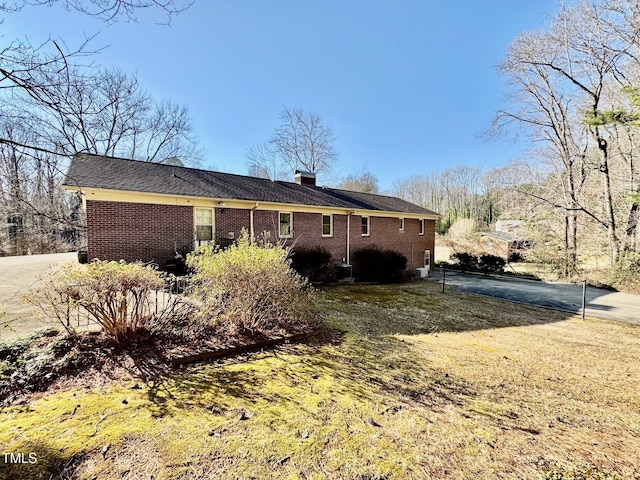 back of property featuring brick siding and a chimney