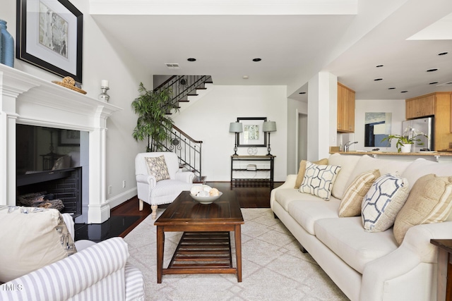 living room with recessed lighting, a fireplace, stairway, light wood-style flooring, and visible vents