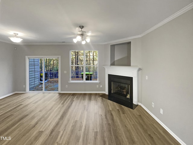 unfurnished living room with a fireplace with flush hearth, crown molding, and wood finished floors