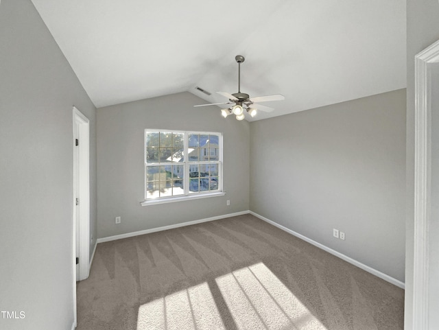 carpeted empty room featuring lofted ceiling, baseboards, visible vents, and a ceiling fan