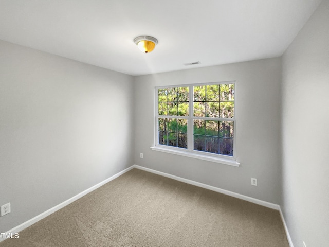 empty room with carpet, baseboards, and visible vents