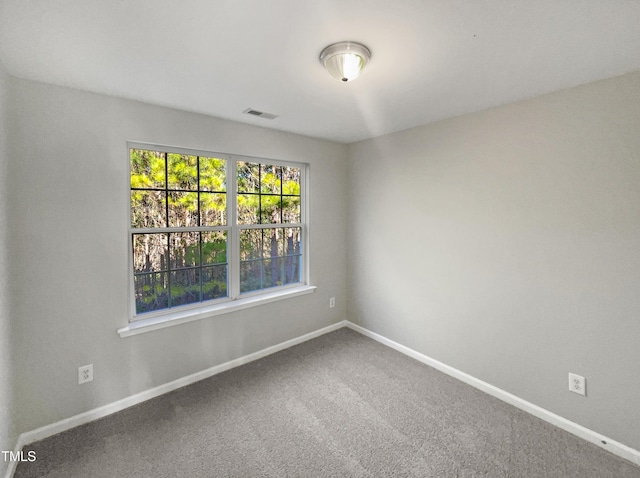 carpeted empty room featuring visible vents and baseboards