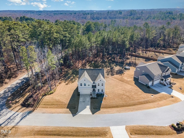 birds eye view of property featuring a forest view