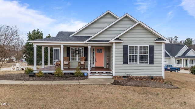 view of front of property featuring covered porch, a front lawn, crawl space, and a shingled roof