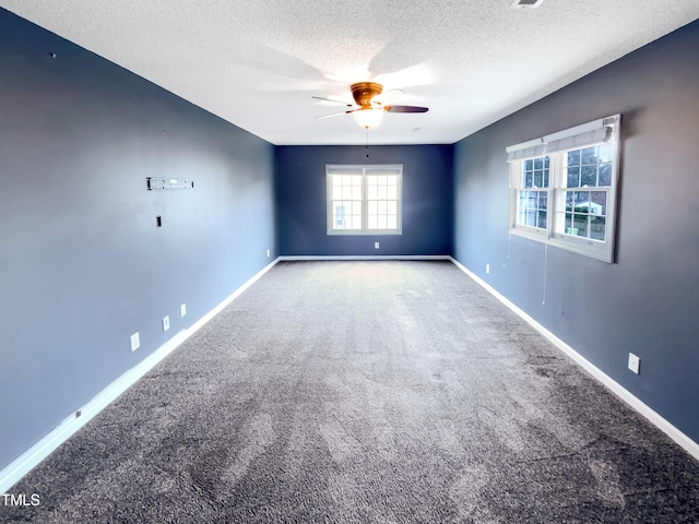 unfurnished room with a ceiling fan, carpet flooring, a textured ceiling, and baseboards