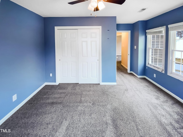 unfurnished bedroom with carpet floors, a closet, visible vents, ceiling fan, and baseboards