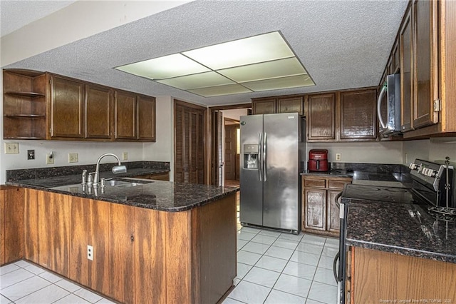 kitchen with light tile patterned floors, stainless steel appliances, a peninsula, a sink, and open shelves