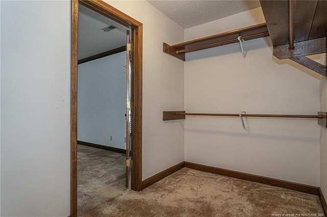 walk in closet featuring visible vents and light colored carpet