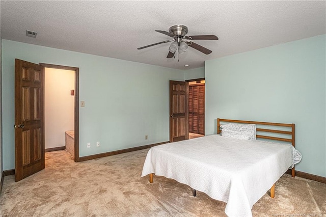 bedroom with baseboards, visible vents, a ceiling fan, light colored carpet, and a textured ceiling