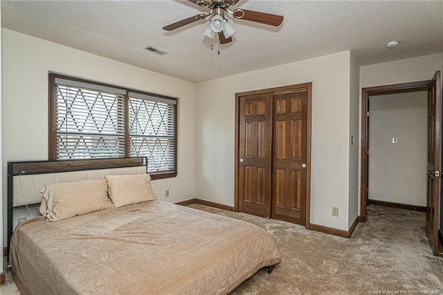 bedroom featuring ceiling fan, a textured ceiling, light colored carpet, visible vents, and baseboards