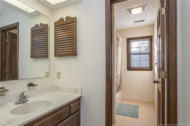 full bath featuring a textured ceiling, shower / bath combo, vanity, and visible vents