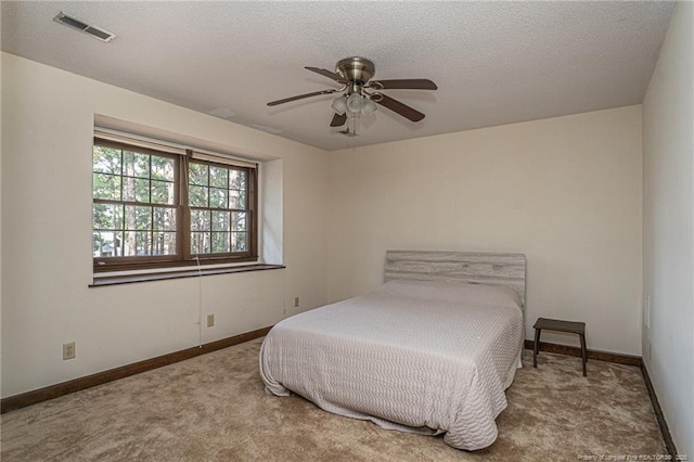 bedroom with baseboards, a textured ceiling, visible vents, and carpet flooring