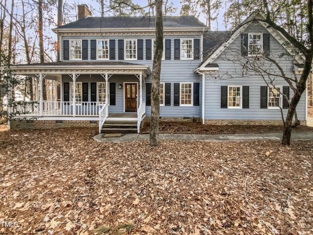 view of front of home featuring a chimney and a porch