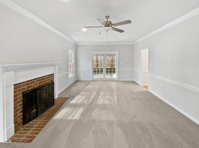 unfurnished living room with a fireplace, a ceiling fan, baseboards, ornamental molding, and carpet