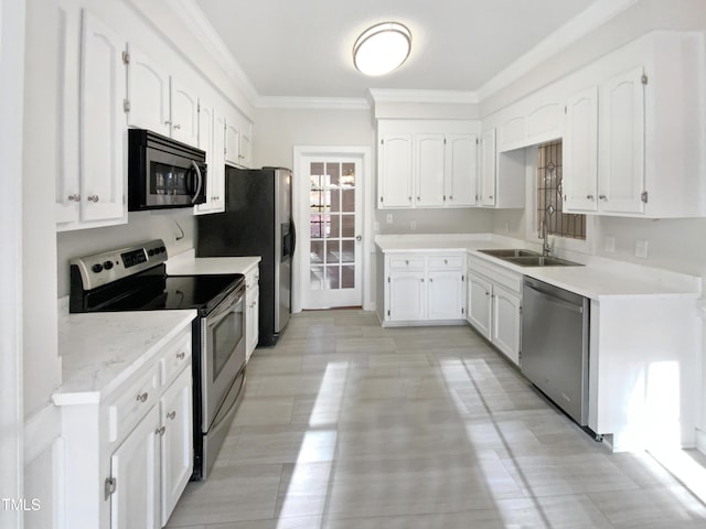 kitchen with stainless steel appliances, white cabinetry, a sink, and ornamental molding