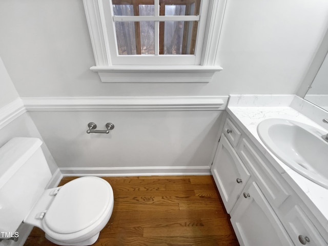 bathroom with toilet, wood finished floors, and vanity