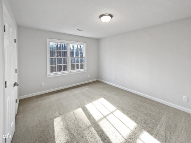 unfurnished room with carpet flooring and baseboards