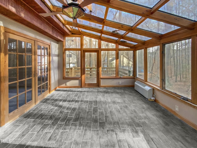 unfurnished sunroom with vaulted ceiling with skylight and radiator