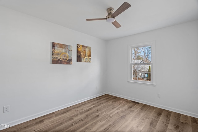 unfurnished room featuring a ceiling fan, visible vents, baseboards, and wood finished floors