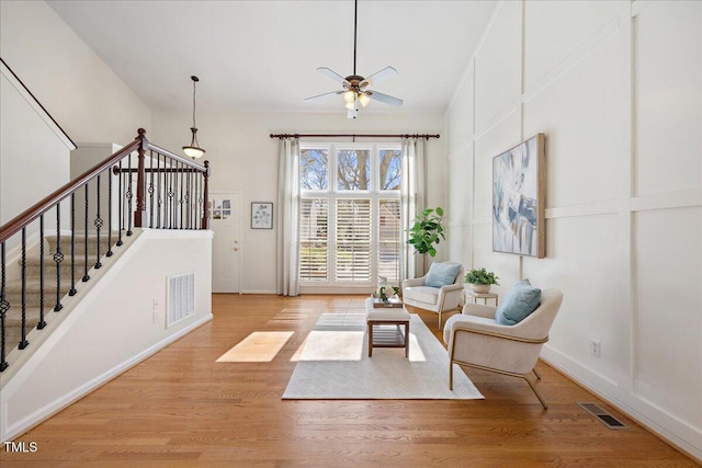 living area with light wood finished floors, stairway, and visible vents