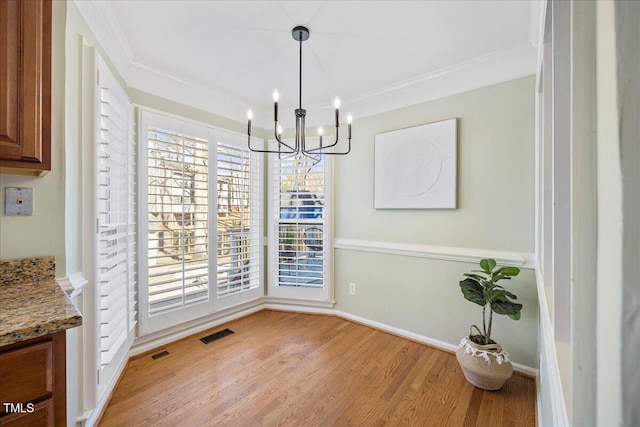 dining space with light wood-style floors, visible vents, and crown molding