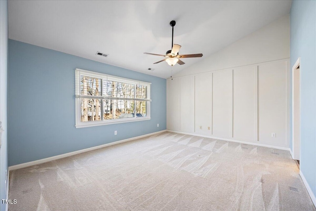 spare room with light colored carpet, visible vents, ceiling fan, and lofted ceiling