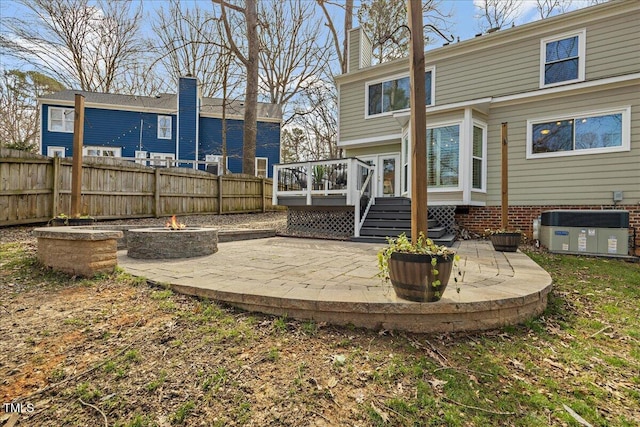 back of house with an outdoor fire pit, fence, a wooden deck, a patio area, and central AC