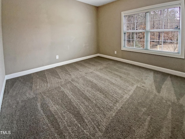 unfurnished room with carpet floors and baseboards