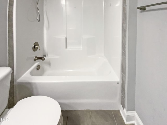 bathroom with shower / washtub combination, toilet, and tile patterned floors