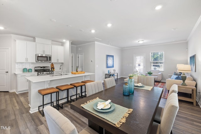 dining area featuring recessed lighting, dark wood-type flooring, baseboards, and ornamental molding