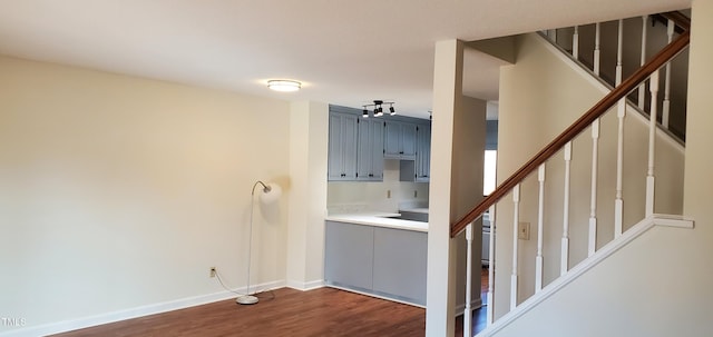 interior space featuring dark wood-style flooring, stairway, and baseboards