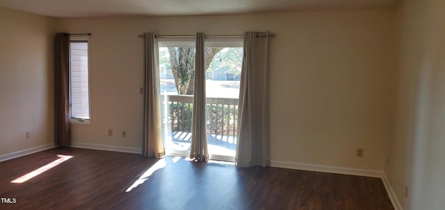 spare room with dark wood-style floors and baseboards