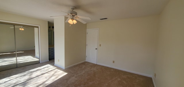 unfurnished bedroom featuring baseboards, visible vents, a ceiling fan, carpet flooring, and a closet