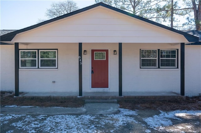 bungalow-style home with covered porch and brick siding