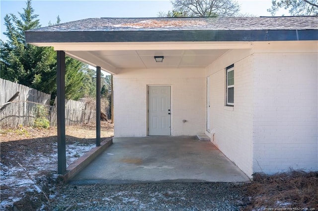 view of patio / terrace with a carport and fence