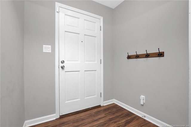 doorway with dark wood-style flooring and baseboards