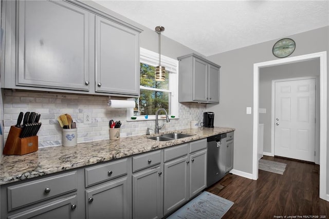 kitchen featuring gray cabinetry, dark wood-type flooring, a sink, dishwasher, and pendant lighting