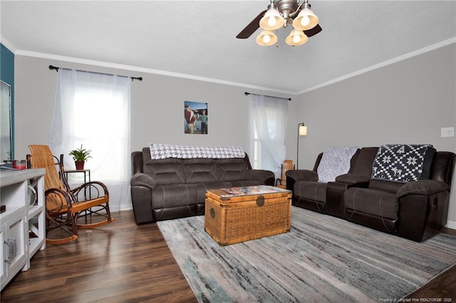 living area featuring a ceiling fan, baseboards, ornamental molding, and dark wood-type flooring