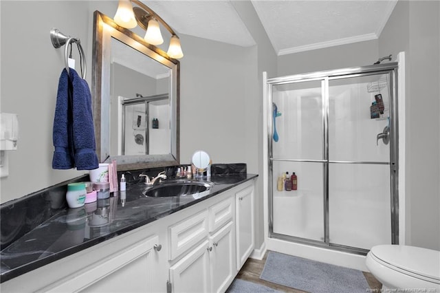 bathroom with toilet, crown molding, vanity, and a shower stall