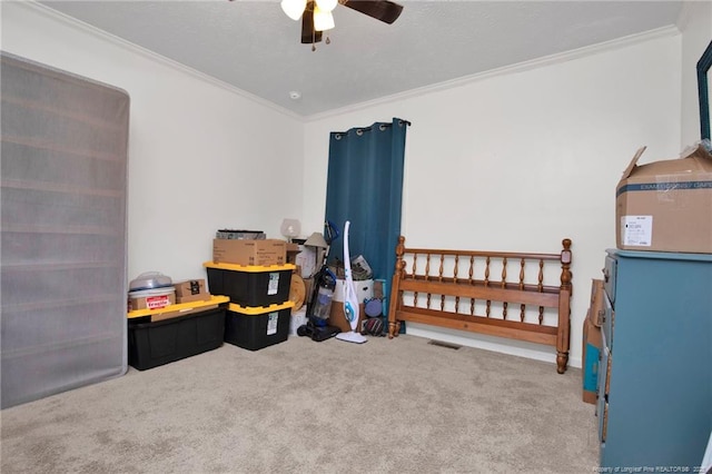 bedroom featuring carpet floors, a ceiling fan, visible vents, and crown molding