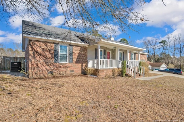 ranch-style home with a porch, brick siding, crawl space, a front lawn, and a chimney