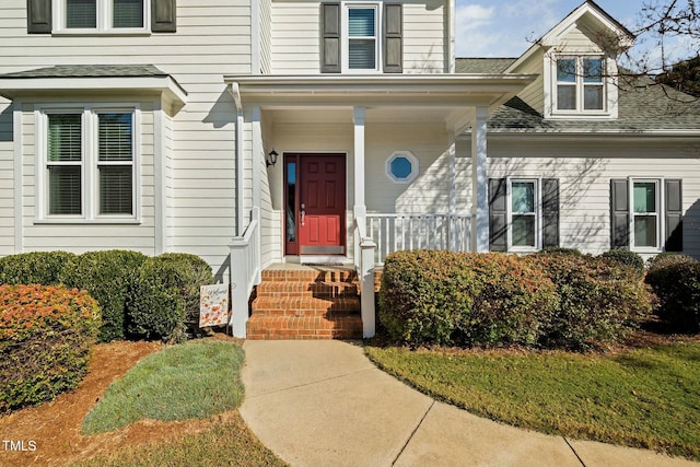 view of exterior entry with a shingled roof