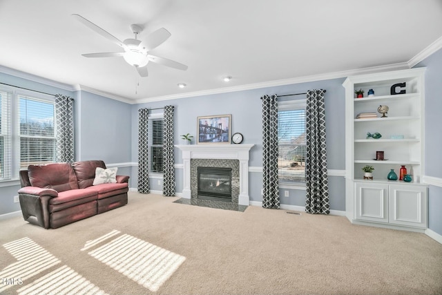 living room featuring crown molding, baseboards, a tile fireplace, and light colored carpet